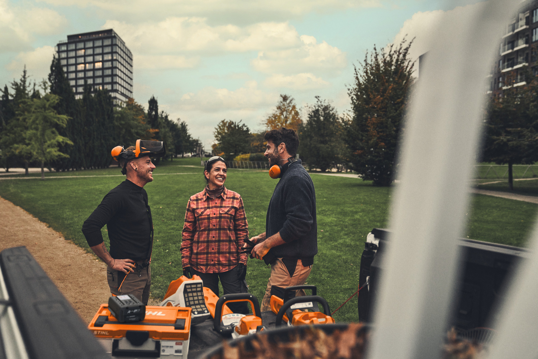 Das Team steht nach getaner Arbeit neben STIHL Akku-Geräten und ALLPRO-Akkus auf der Ladefläche ihres Pickups