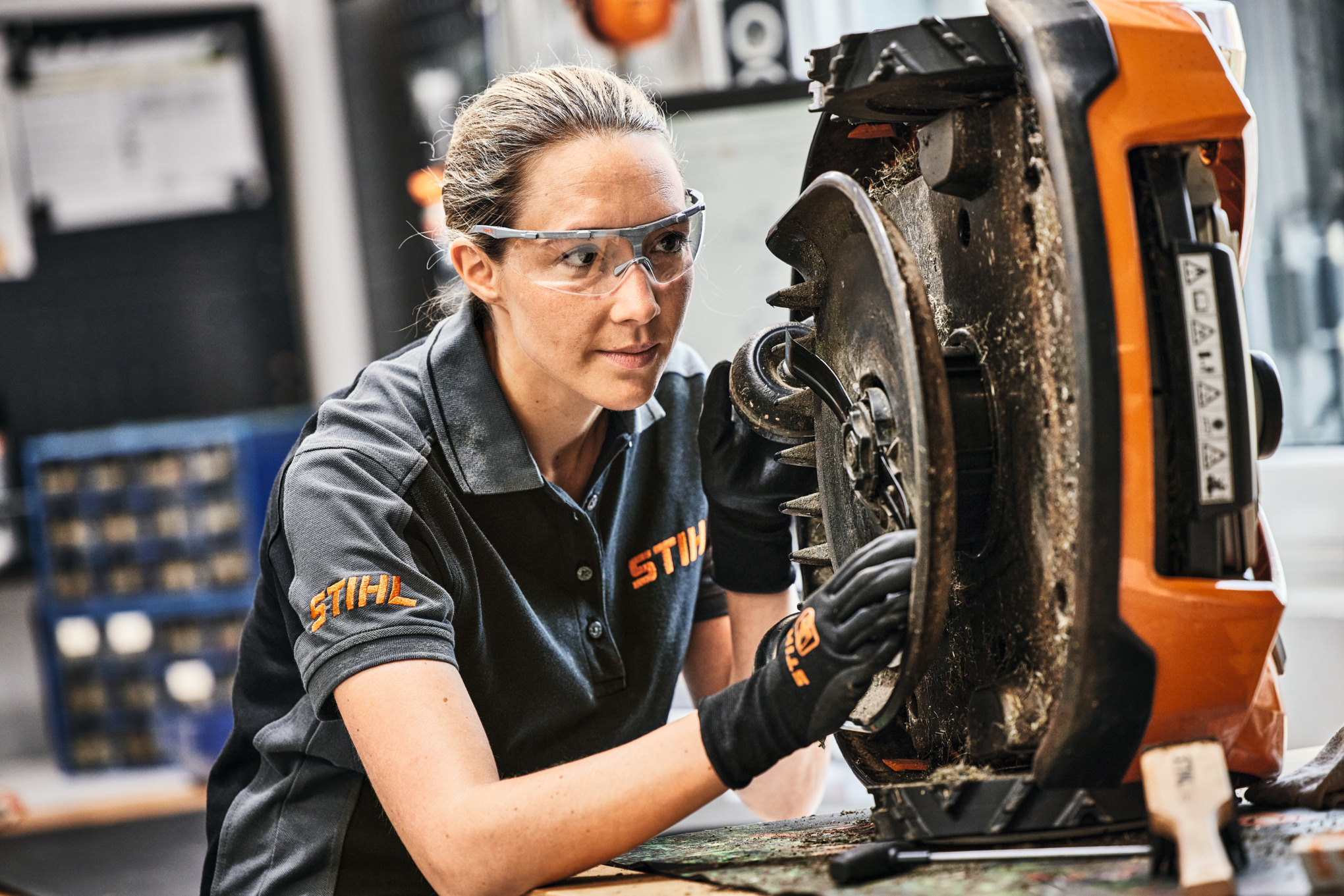 STIHL Fachhändlerin bei der Wartung eines STIHL iMOW Mähroboters