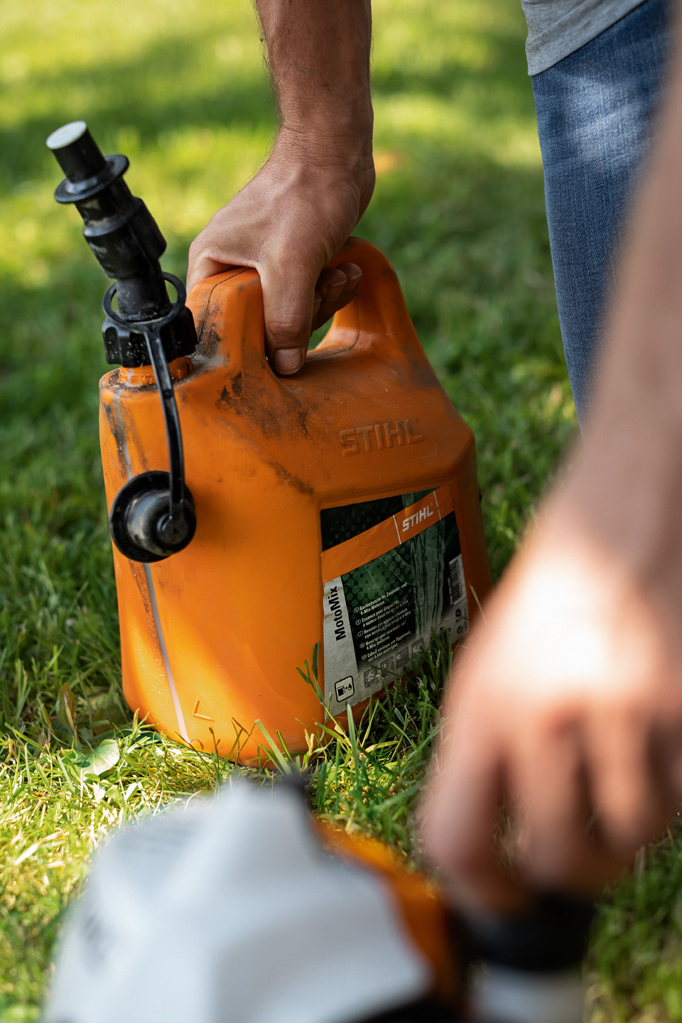 Mann hält Kanister mit Kraftstoffgemisch STIHL MotoMix