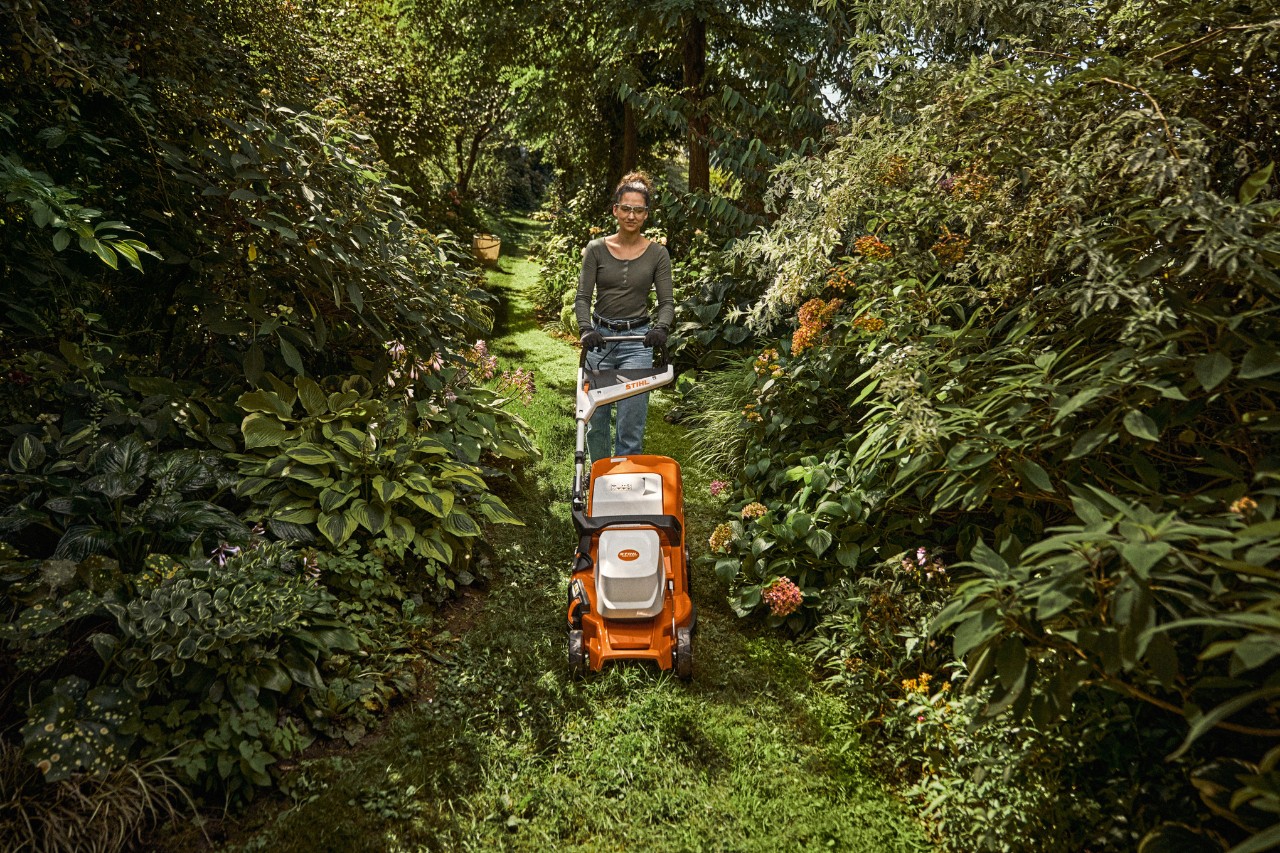 Banner: Frau mit STIHL Akku-Rasenmäher in der Natur