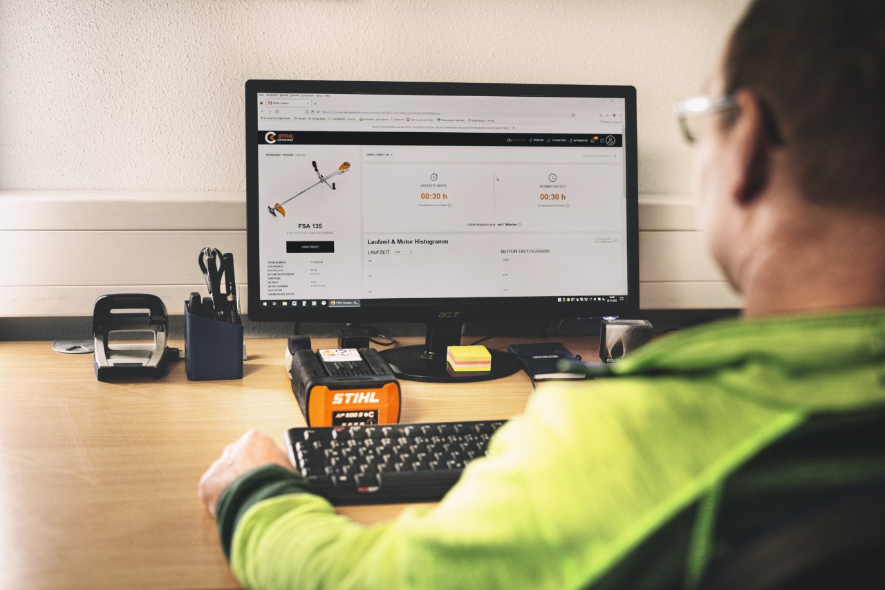 Ein Mann sitzt im Büro vor dem PC und hat das STIHL connected Portal geöffnet