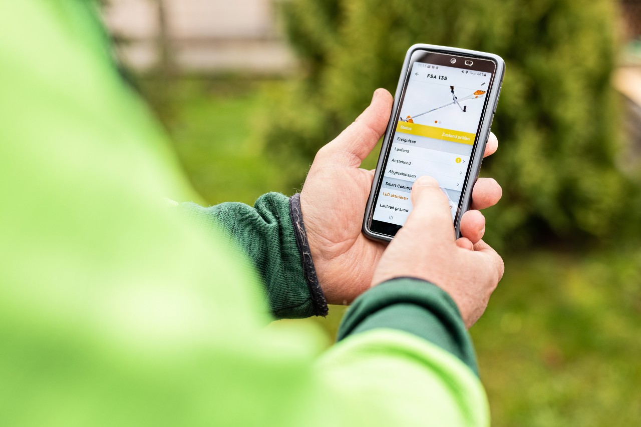 Nahaufnahme, wie jemand am Smartphone die STIHL connected App bedient