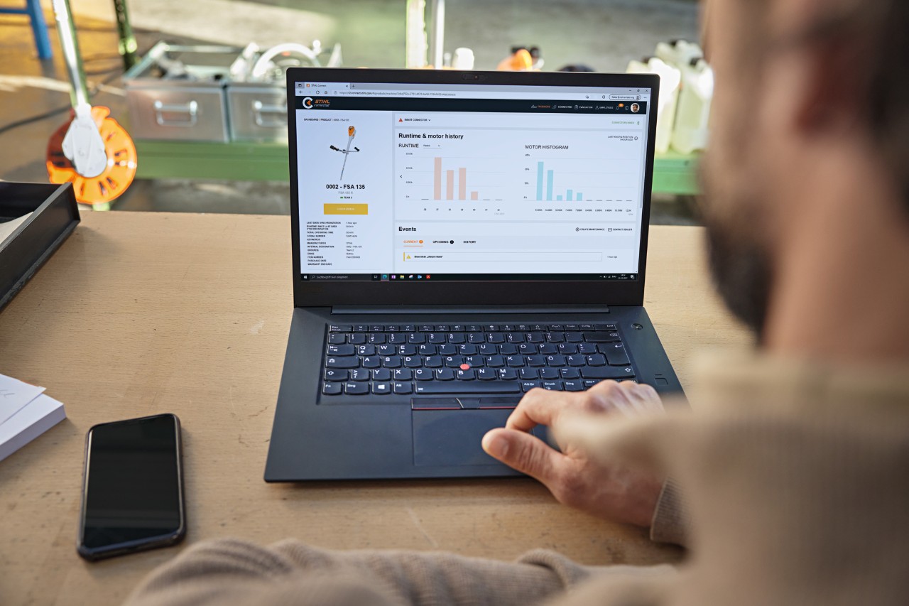 Person sitzt vor seinem Computer und prüft den Gerätestand mit dem STIHL connected Portal