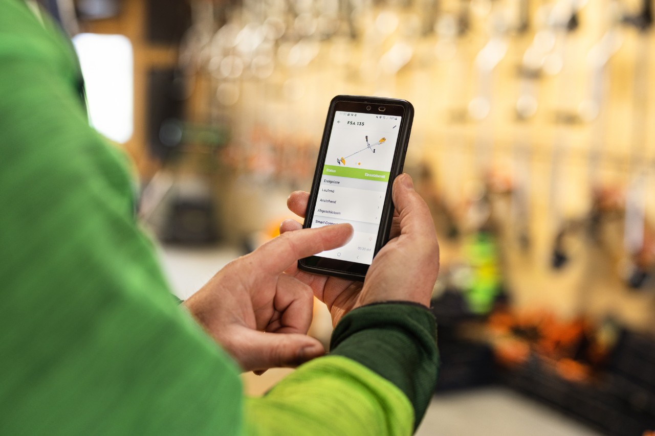 Close up: Ein Mann verwaltet STIHL connected Geräteflotte an seinem Handy