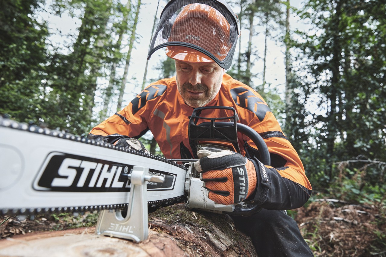 Ein Mann in Schutzausrüstung arbeitet mit einer STIHL Motorsäge im Forst