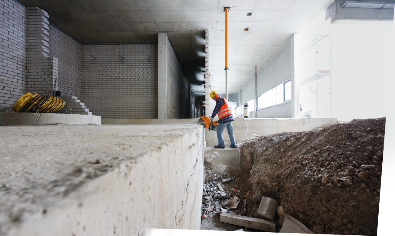 Ein Mann mit einem Benzin-Trennschleifer STIHL TS 500i zerteilt einen Stahlbolzen auf einer Baustelle