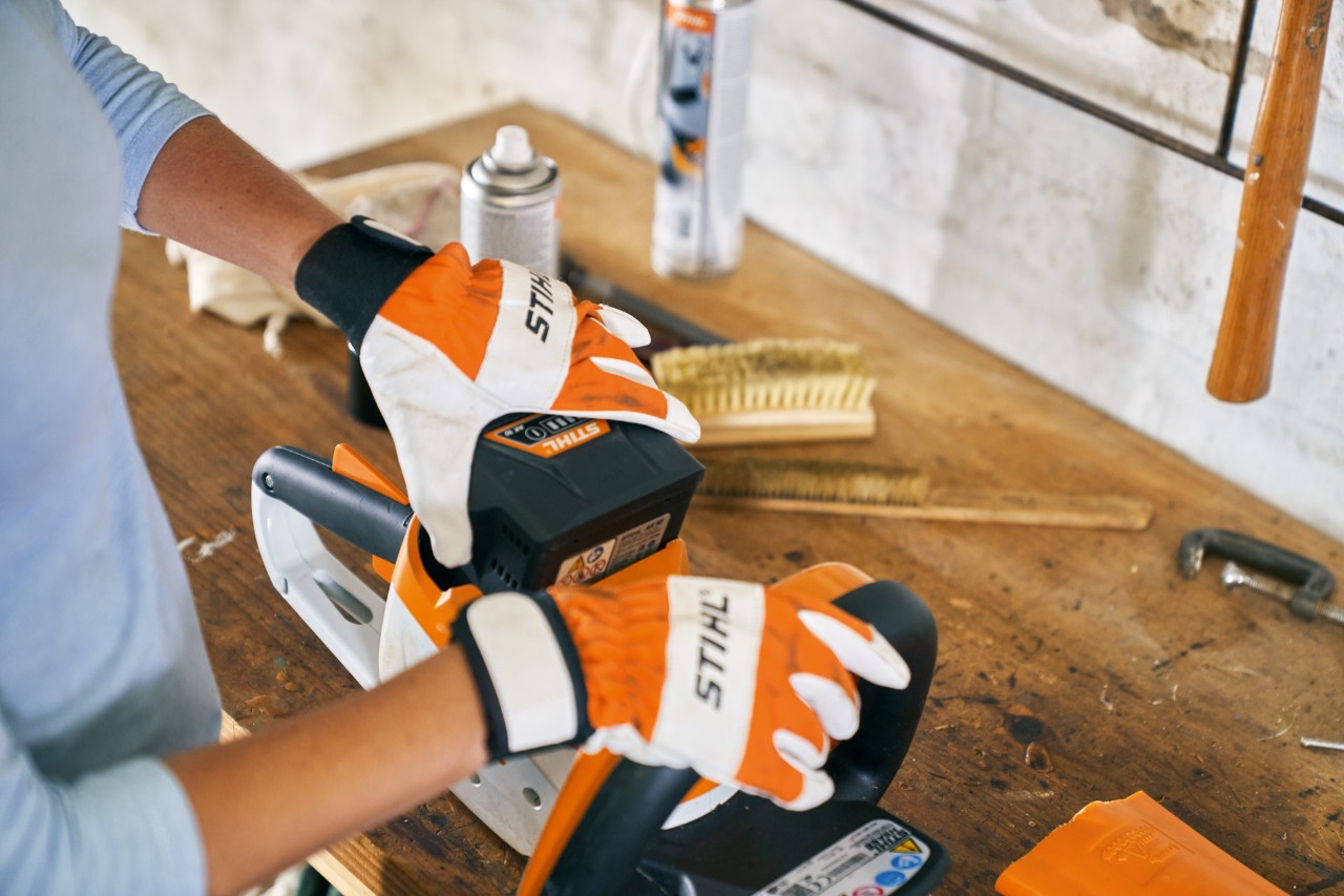 Person arbeitet mit Handschuhen an der STIHL Akku-Heckenschere HSA 56 