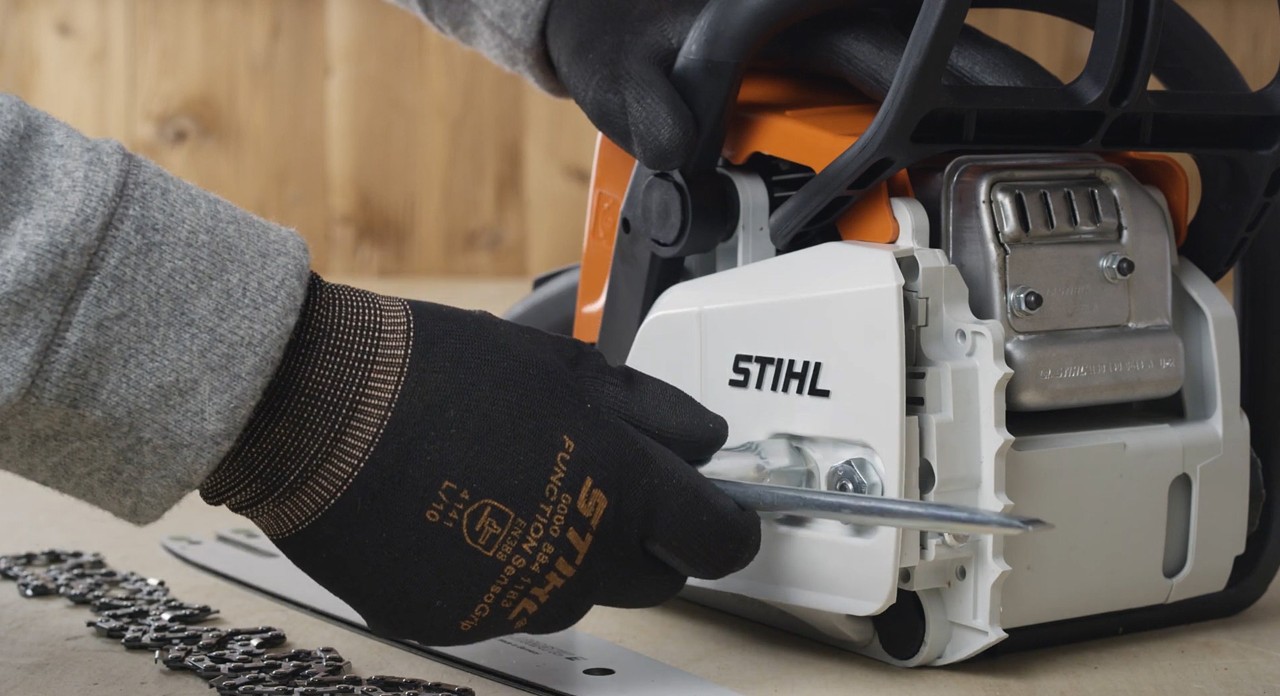 Kettenraddeckel einer STIHL Benzin-Motorsäge MS 170 wird abgenommen, um Schneidgarnitur der Kettensäge zu montieren