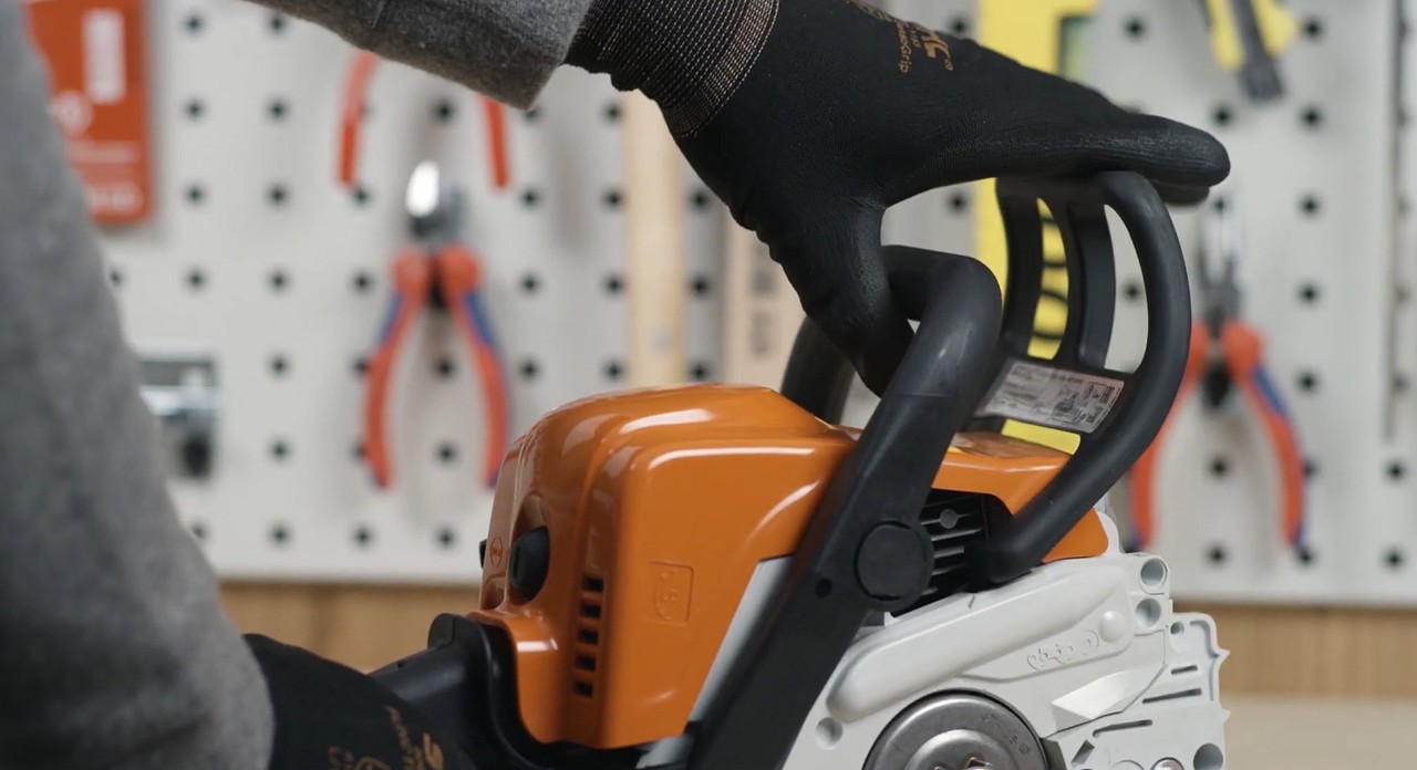 Handschutz einer STIHL Benzin-Motorsäge MS 170 wird zum Griffrohr gezogen, um Kettenbremse zu lösen