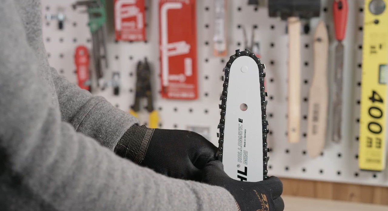 Sägekette wird in die Nut der Führungsschiene einer STIHL Motorsäge gelegt