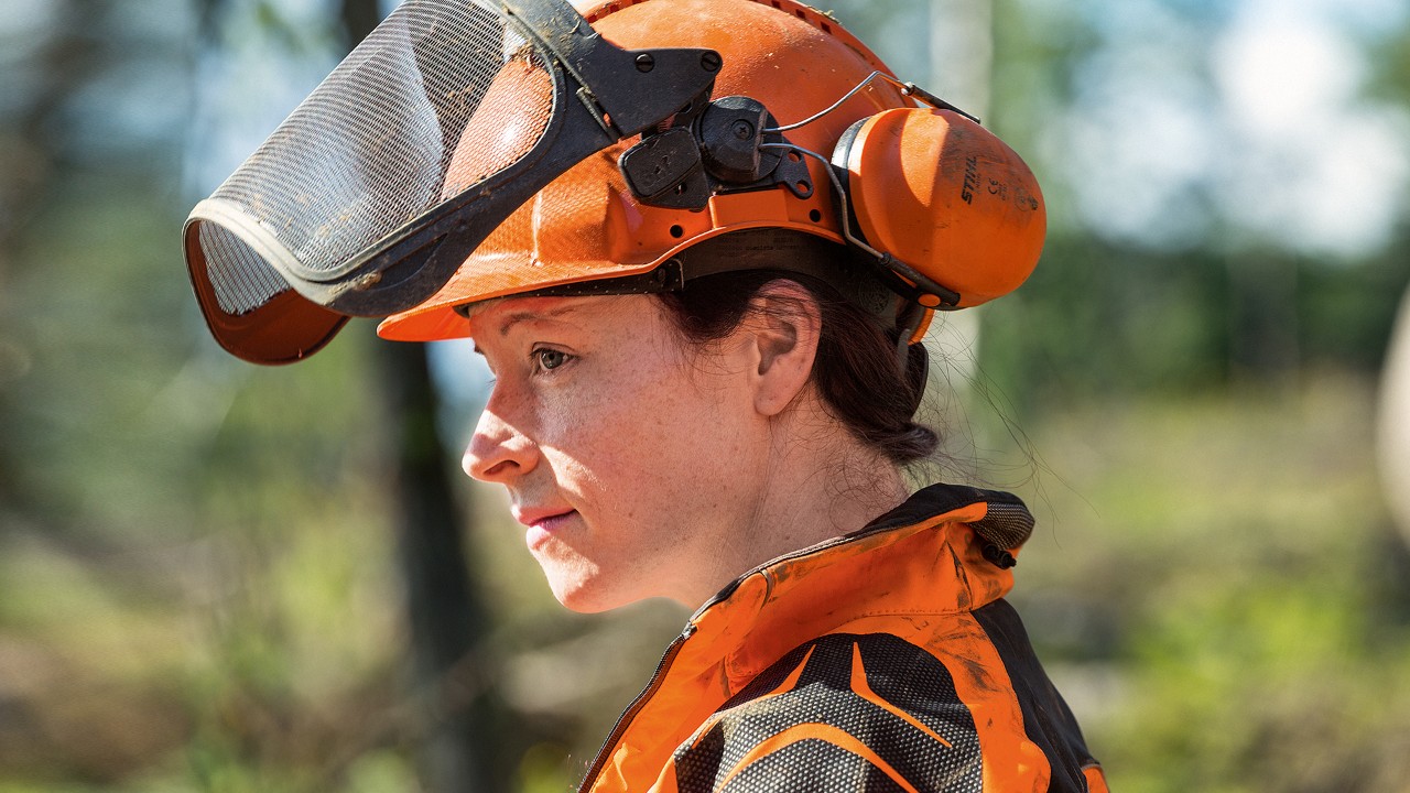 Frau mit STIHL Helmset inklusive Gesichtsschutz, Gehörschutz und Helm