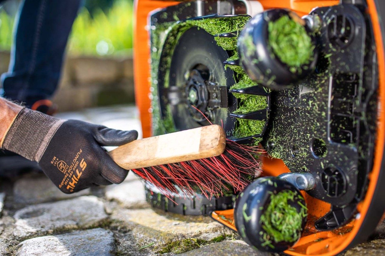 Messer des STIHL iMOW® Mähroboters 422 werden mit einer Bürste gereinigt