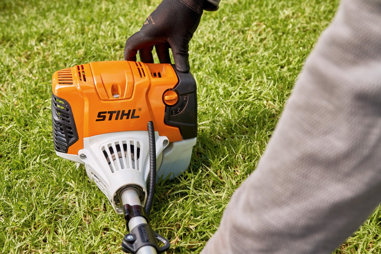 Mann drückt die Benzin-Motorsense STIHL FS 91 fest auf den Boden