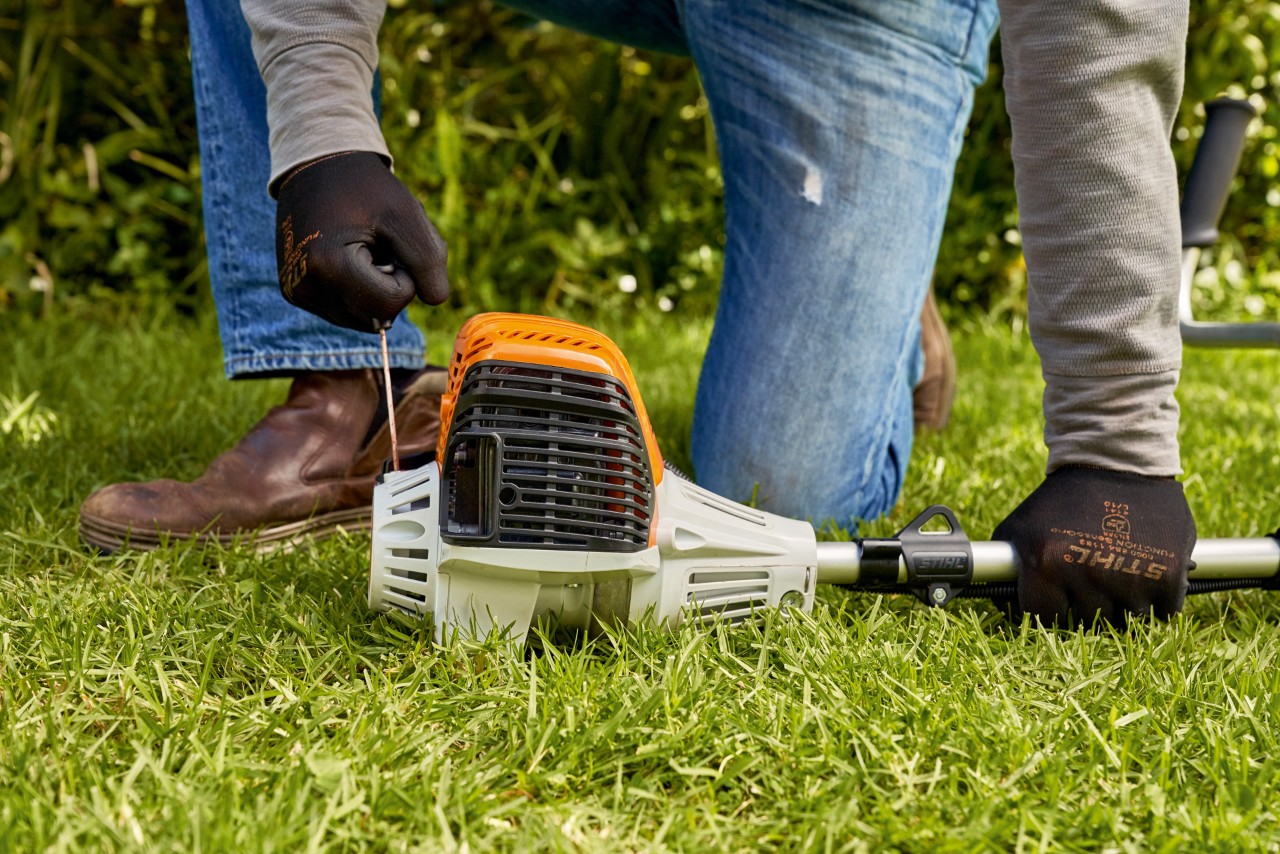 Mann zieht das Anwerfseil der Benzin-Motorsense STIHL FS 91 