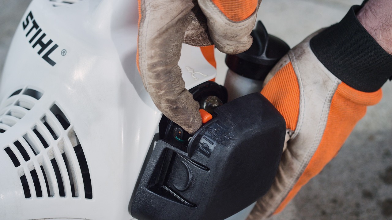 An der Benzin-Motorsense STIHL FS 38 wird der Hebel der Startklappe betätigt