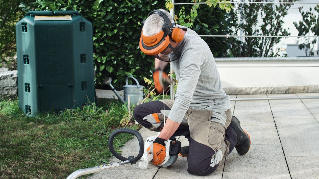 Person in Schutzkleidung zieht am Anwerfseil der Benzin-Motorsense STIHL FS 38