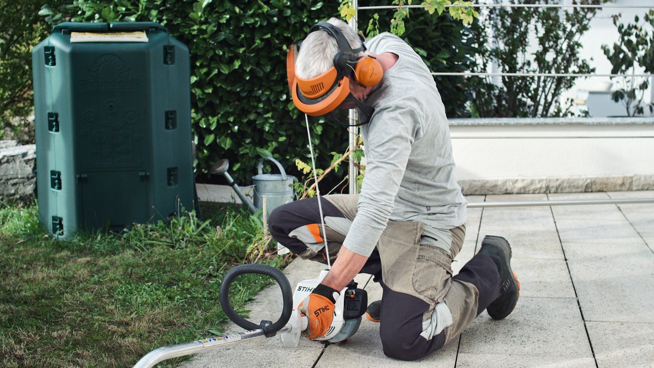 Person in Schutzkleidung zieht erneut am Anwerfseil der Benzin-Motorsense STIHL FS 38