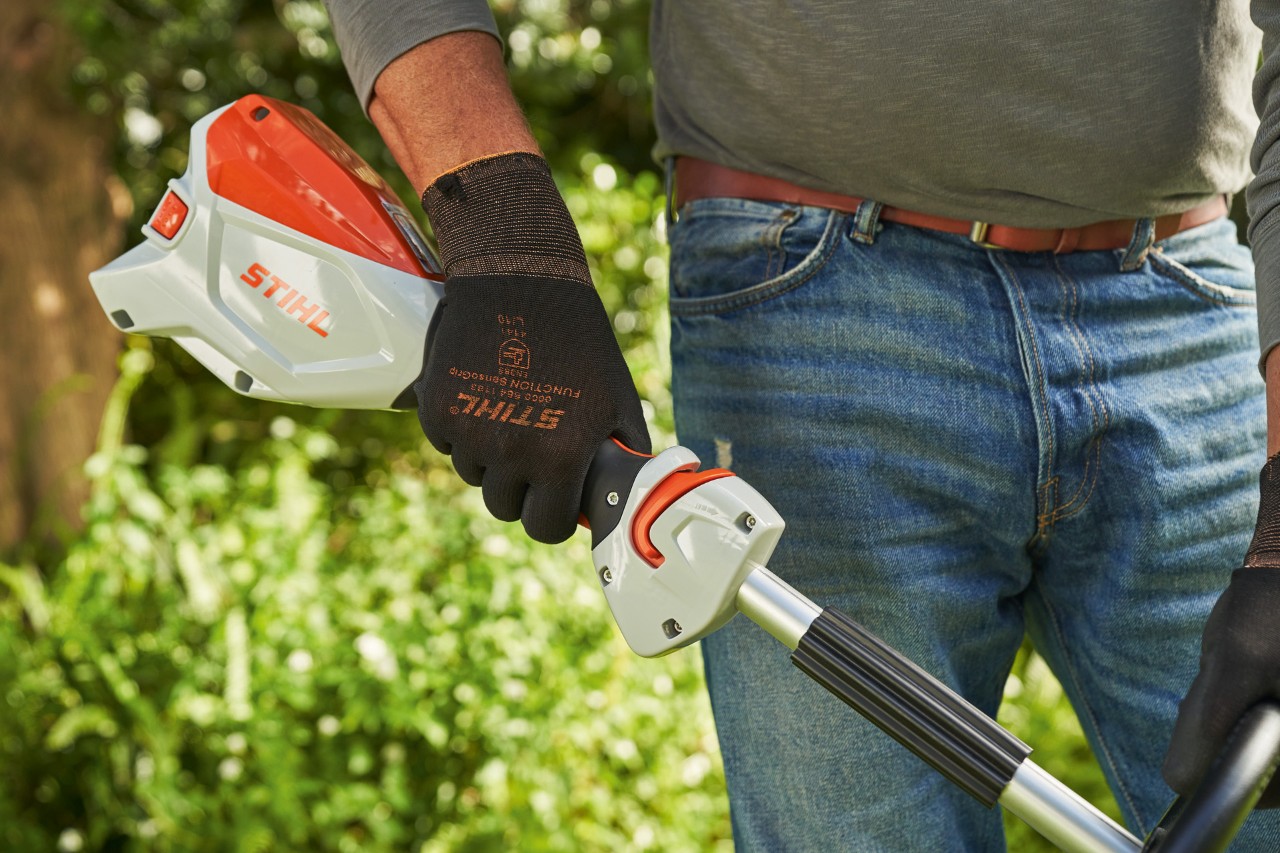 Mann mit Schutzhandschuhen betätigt den Schalthebel der Akku-Motorsense STIHL FSA 60, um sie zu starten