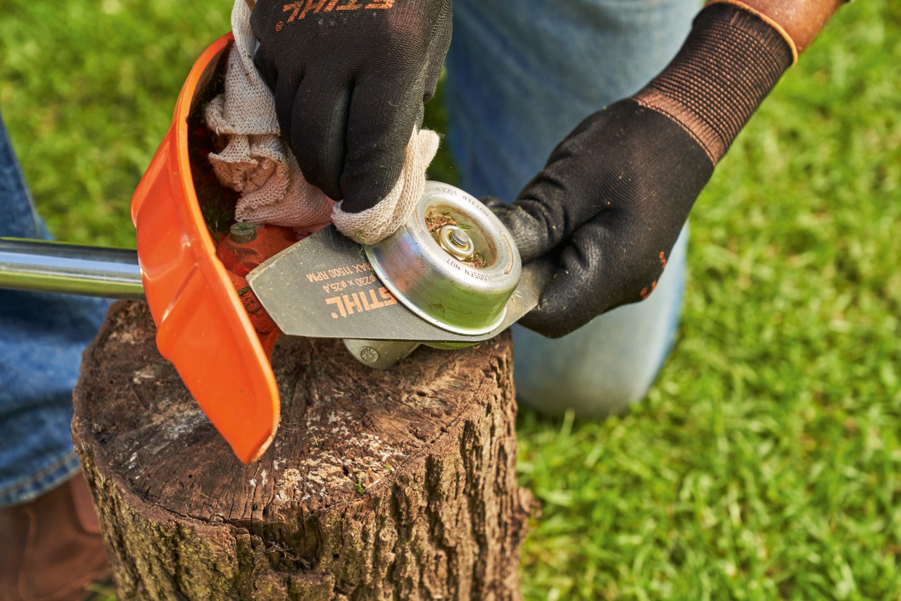 Dickichtmesser einer STIHL Motorsense wird mit einem feuchten Tuch gereinigt