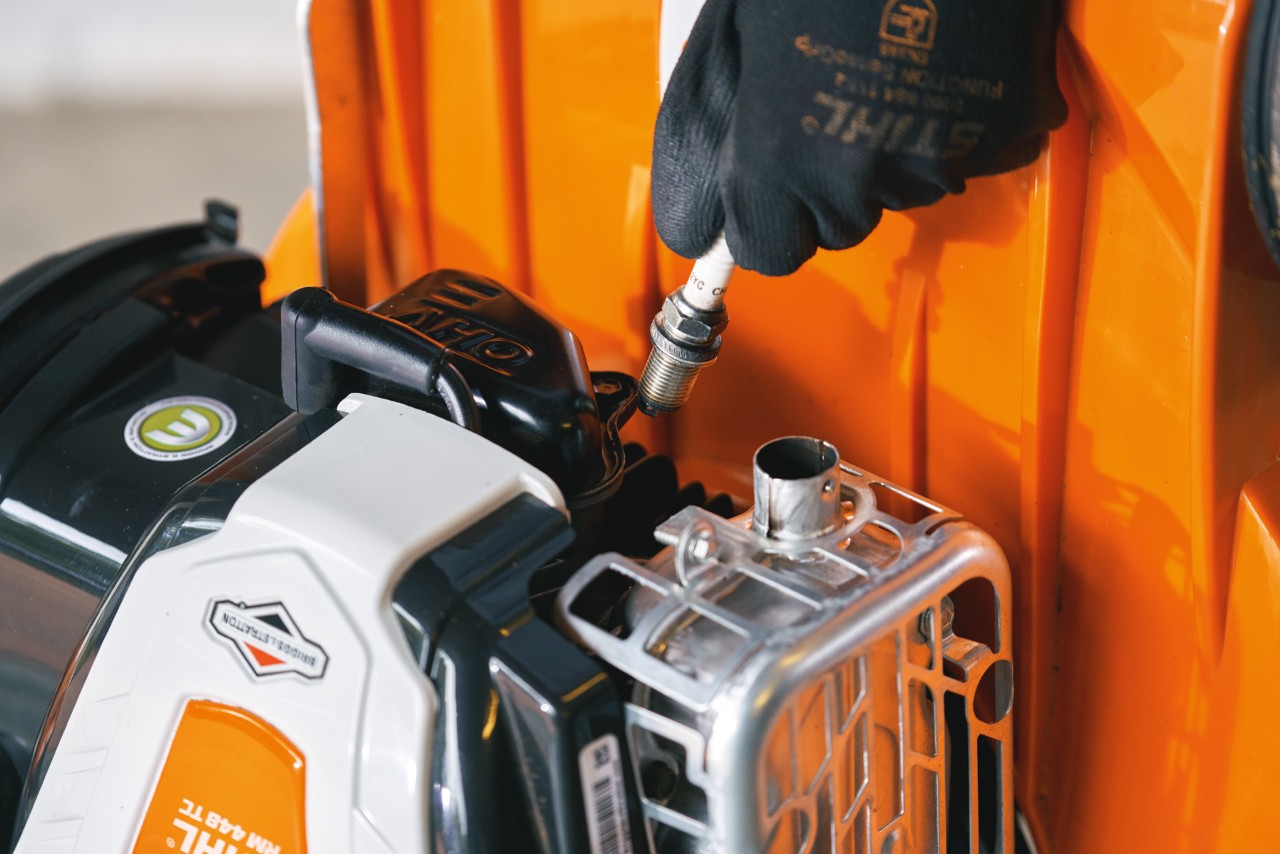 Zündkerze wird aus dem Motor des STIHL Benzin-Rasenmähers RM 448 TC entfernt