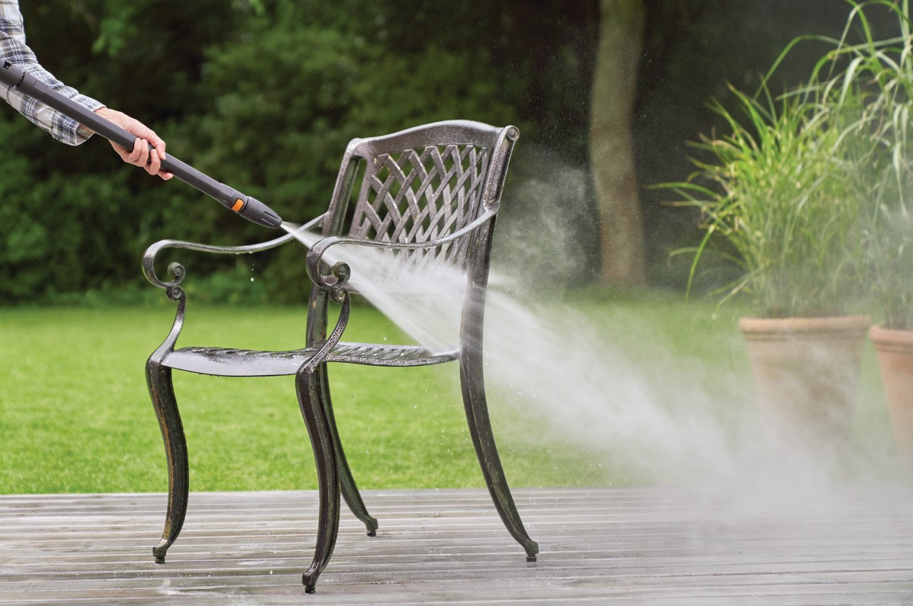 Gartenstuhl aus Metall wird mit STIHL Hochdruckreiniger RE 130 plus gereinigt