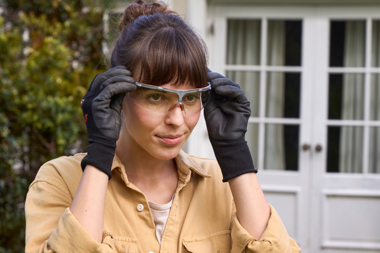 Eine Frau setzt ihre Schutzbrille auf