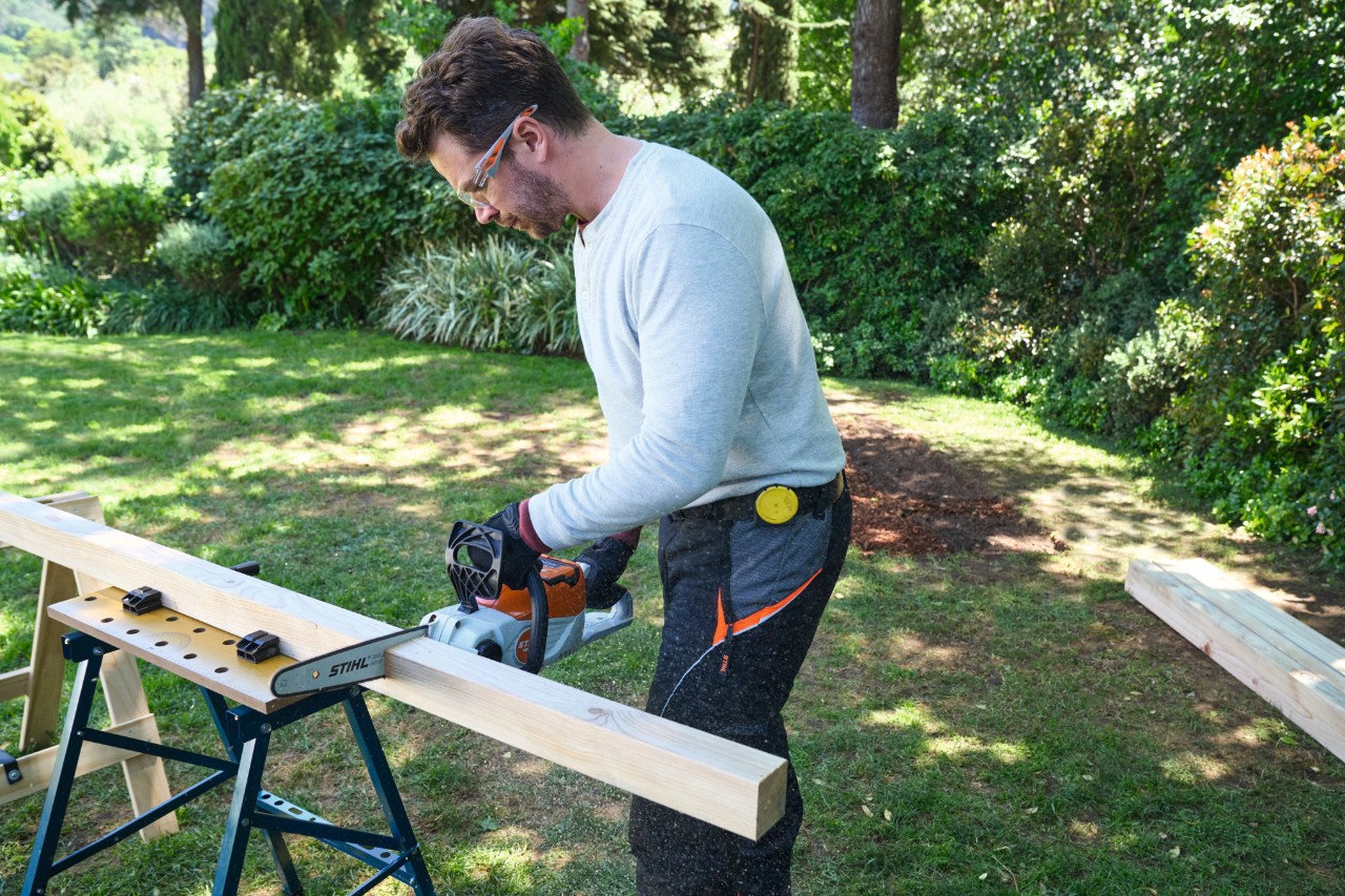 Ein Mann sägt einen Pfosten mit der Akku-Säge STIHL MSA 70 in die richtige Länge