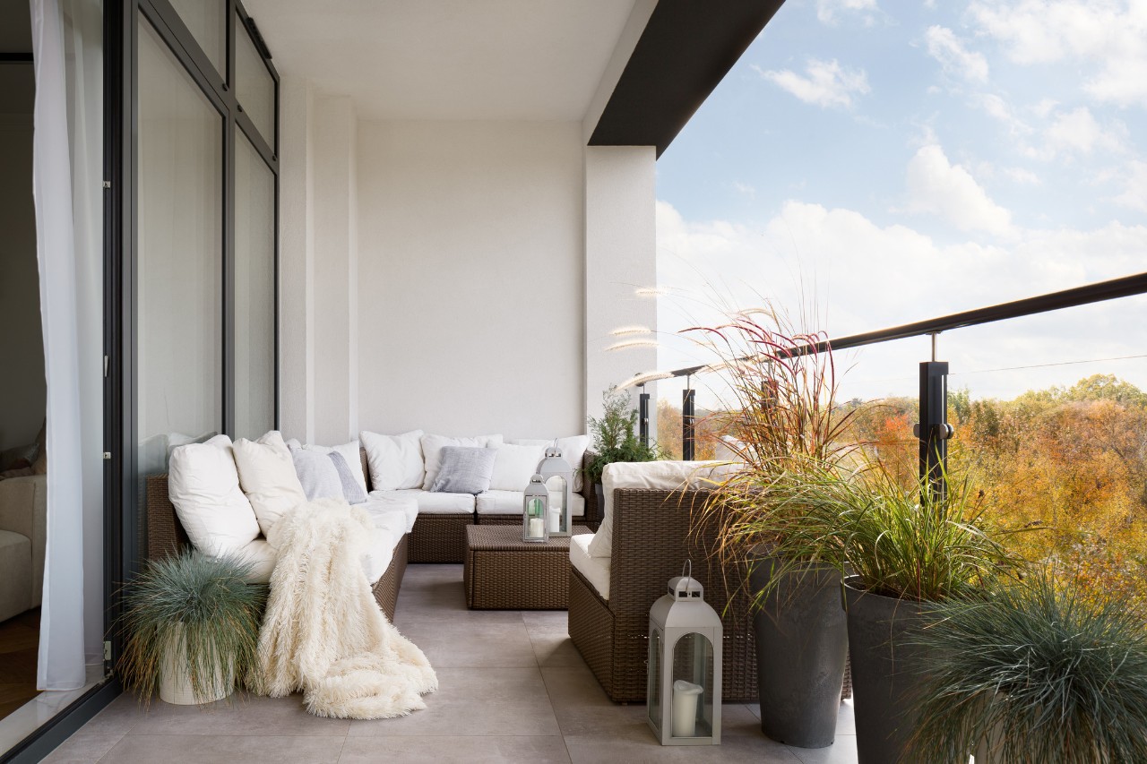 Dachterrasse gestalten mit gepolsterter Sitzecke, Laternen und Pflanztrögen