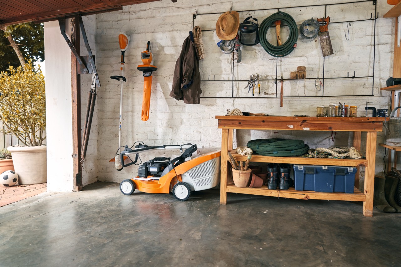 Benzin-Rasenmäher STIHL RM 448 TC neben anderen STIHL Geräten in einer Garage