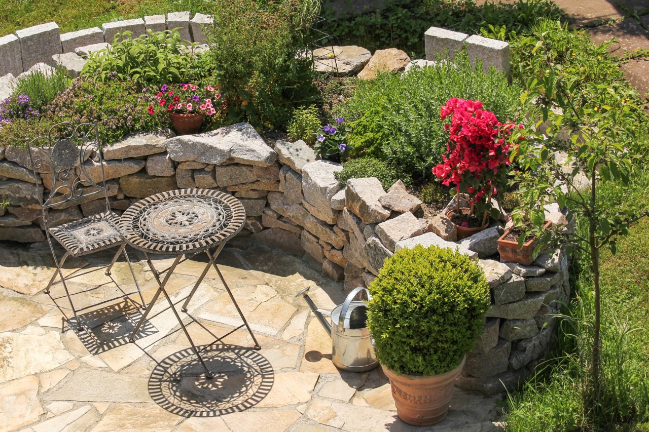 Mediterraner Hanggarten mit Terrasse und Gartenmöbeln