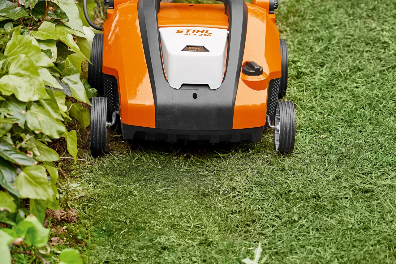 Nahaufnahme vom STIHL Akku-Rasenlüfter RLA 240 vor dem Rasensanden