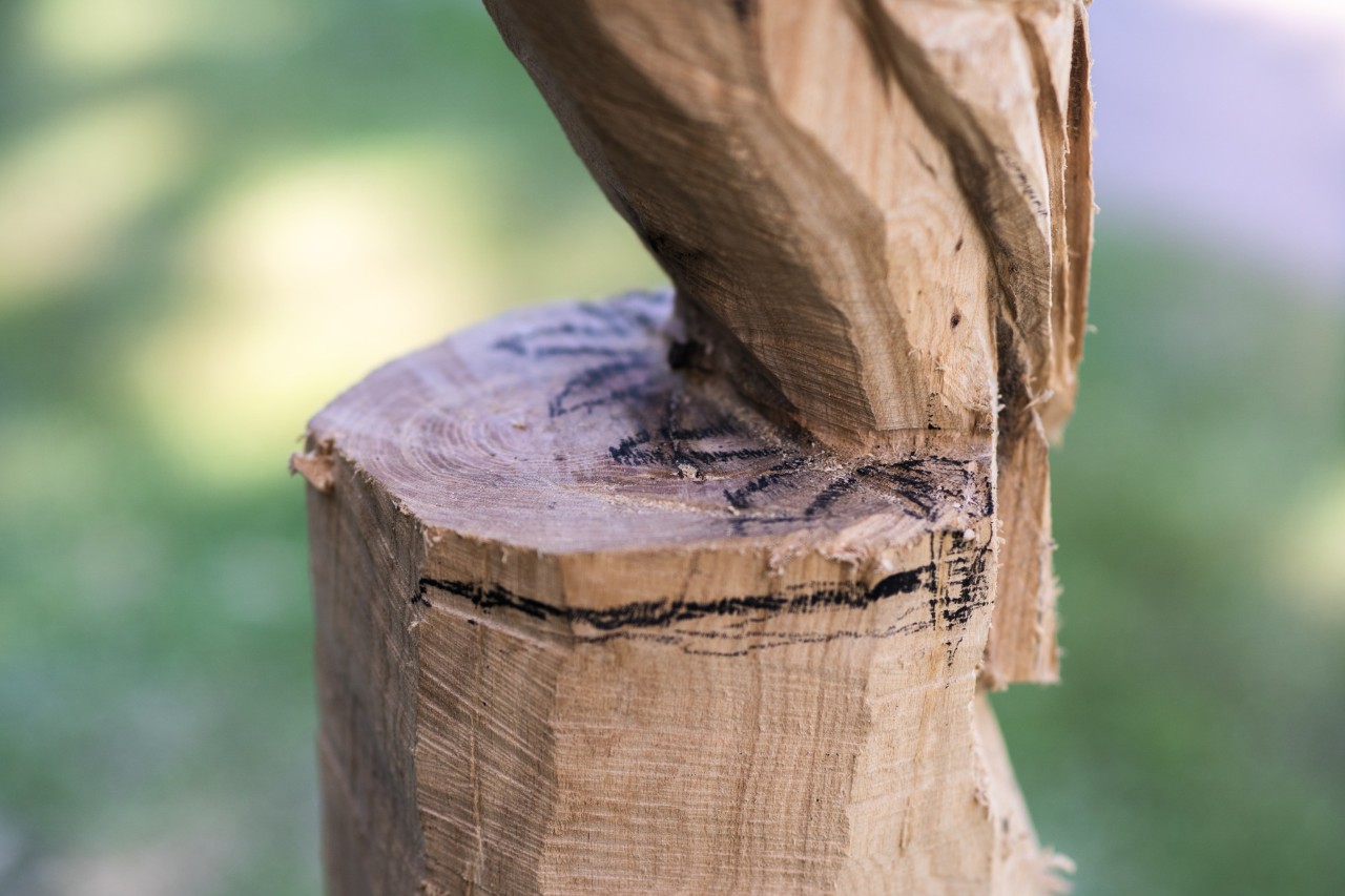 Die Krallen der Eule aus Holz werden auf dem Sockel angezeichnet