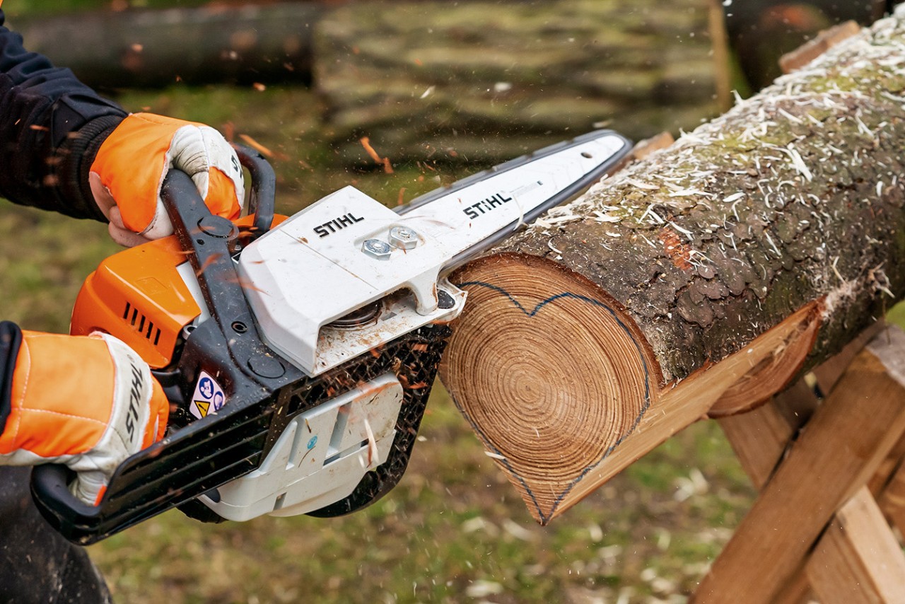 Mit einer STIHL Benzin-Kettensäge MS 170 wird die Grundform des Herzes gesägt