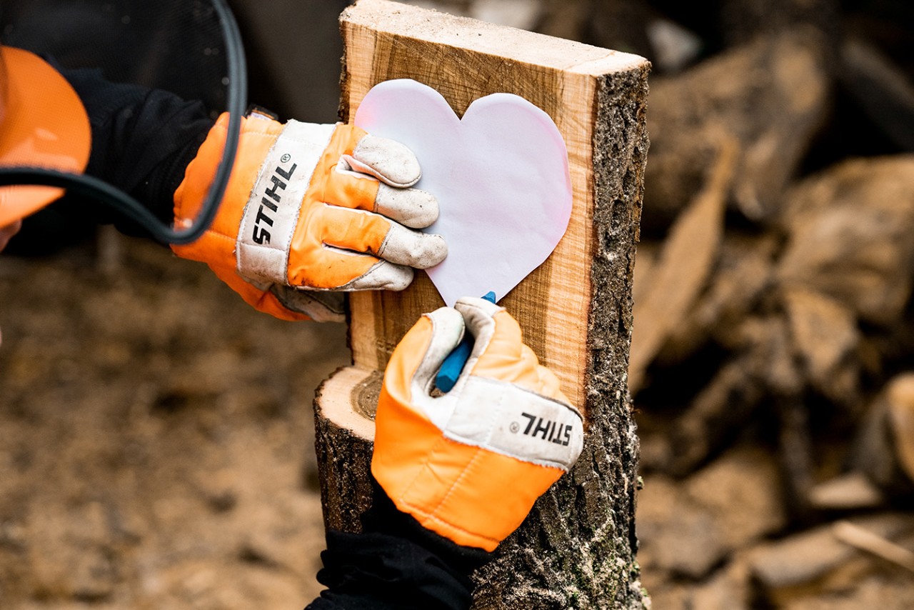 Mit Signierkreide und eine herzförmigen Schablone wird die Herzform auf das Holz übertragen
