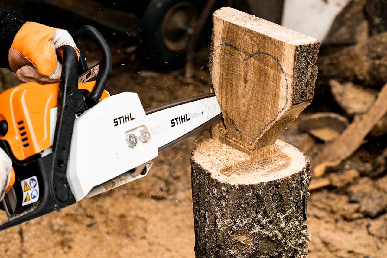 Mit einer STIHL Benzin-Kettensäge MS 170 wird das Holz in Herzform ausgesägt