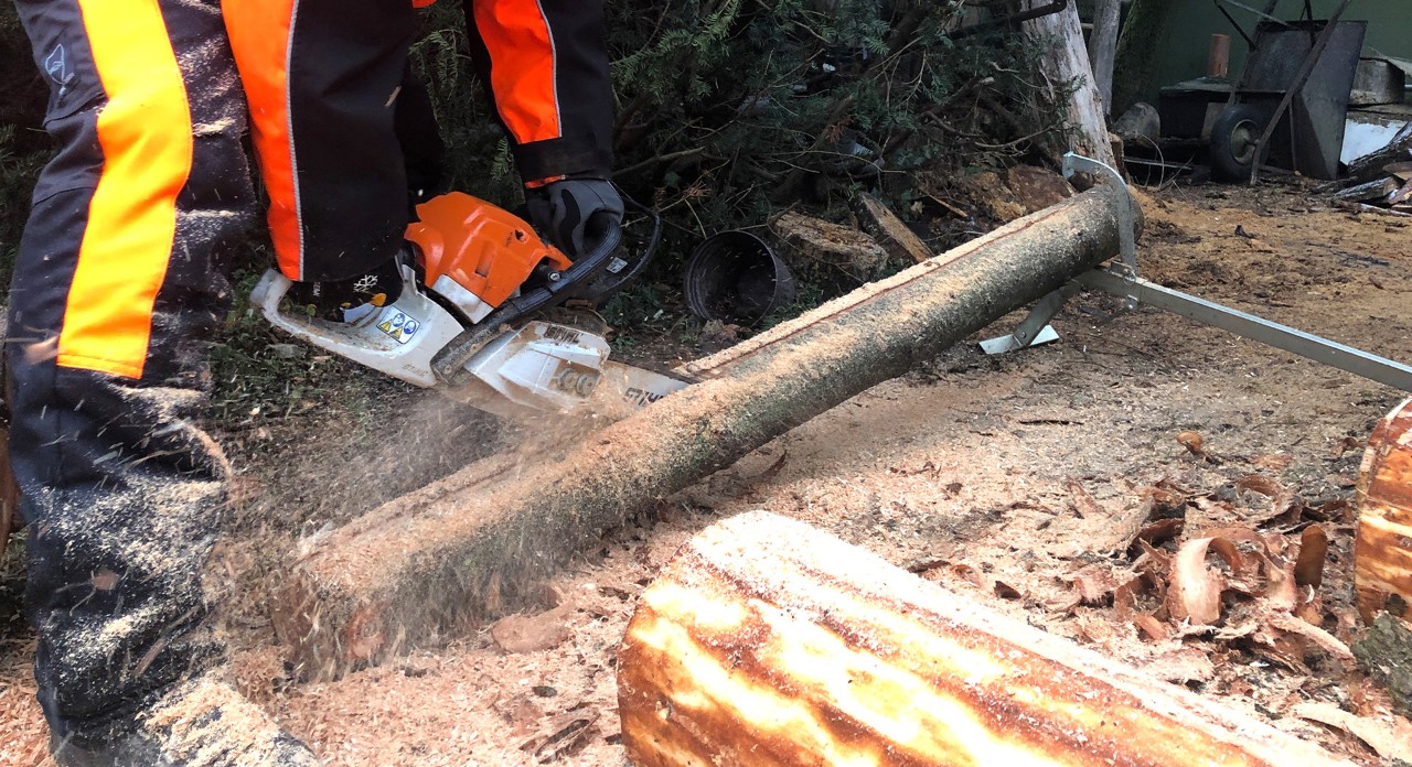 Fixiertes Rundholz wird mit einer STIHL Benzin-Kettensäge MS 170 der Länge nach halbiert