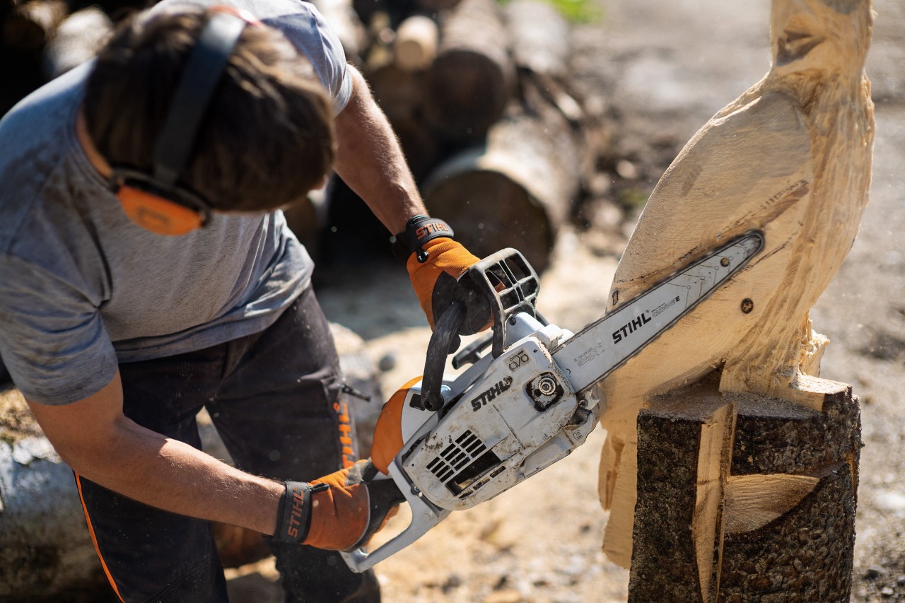 Mann schnitzt mit STIHL Carvingsäge einen Vogel aus Holz