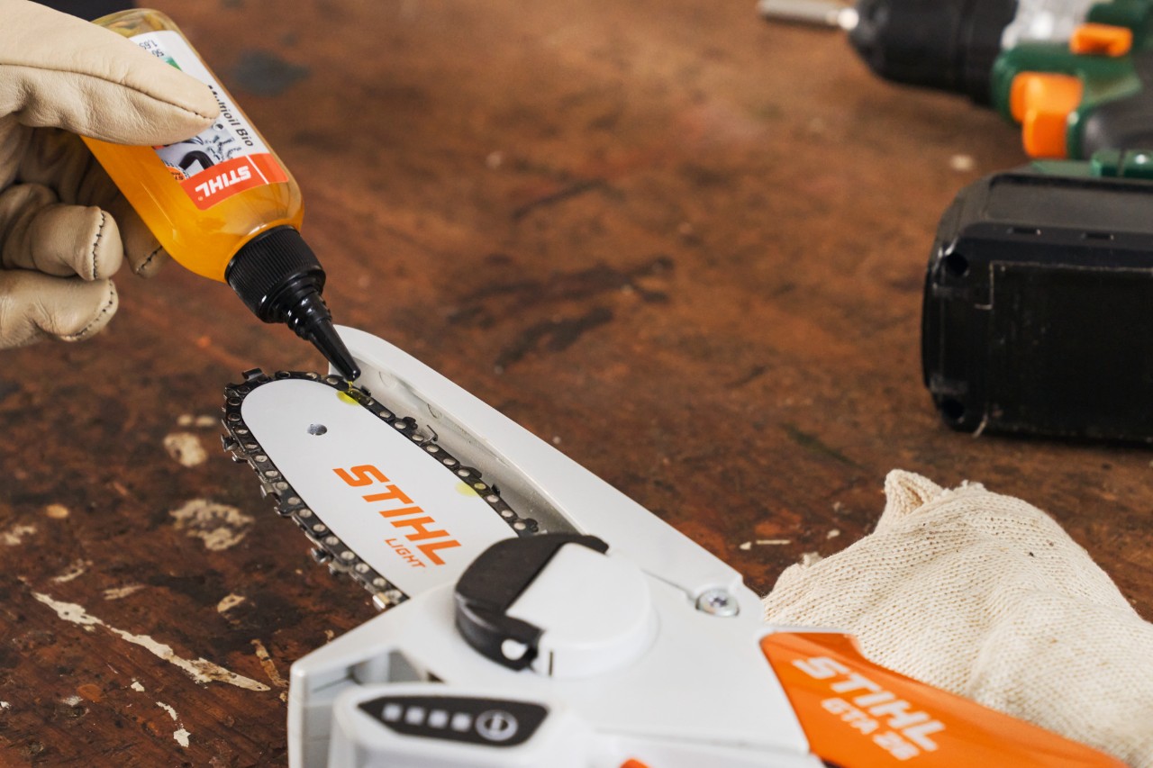Eine Person ölt den Gehölzschneider STIHL GTA 26