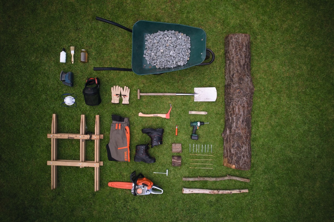  Geeignete Werkzeuge und Materialien für den Bau einer Gartenbank sind auf dem Rasen bereitgelegt