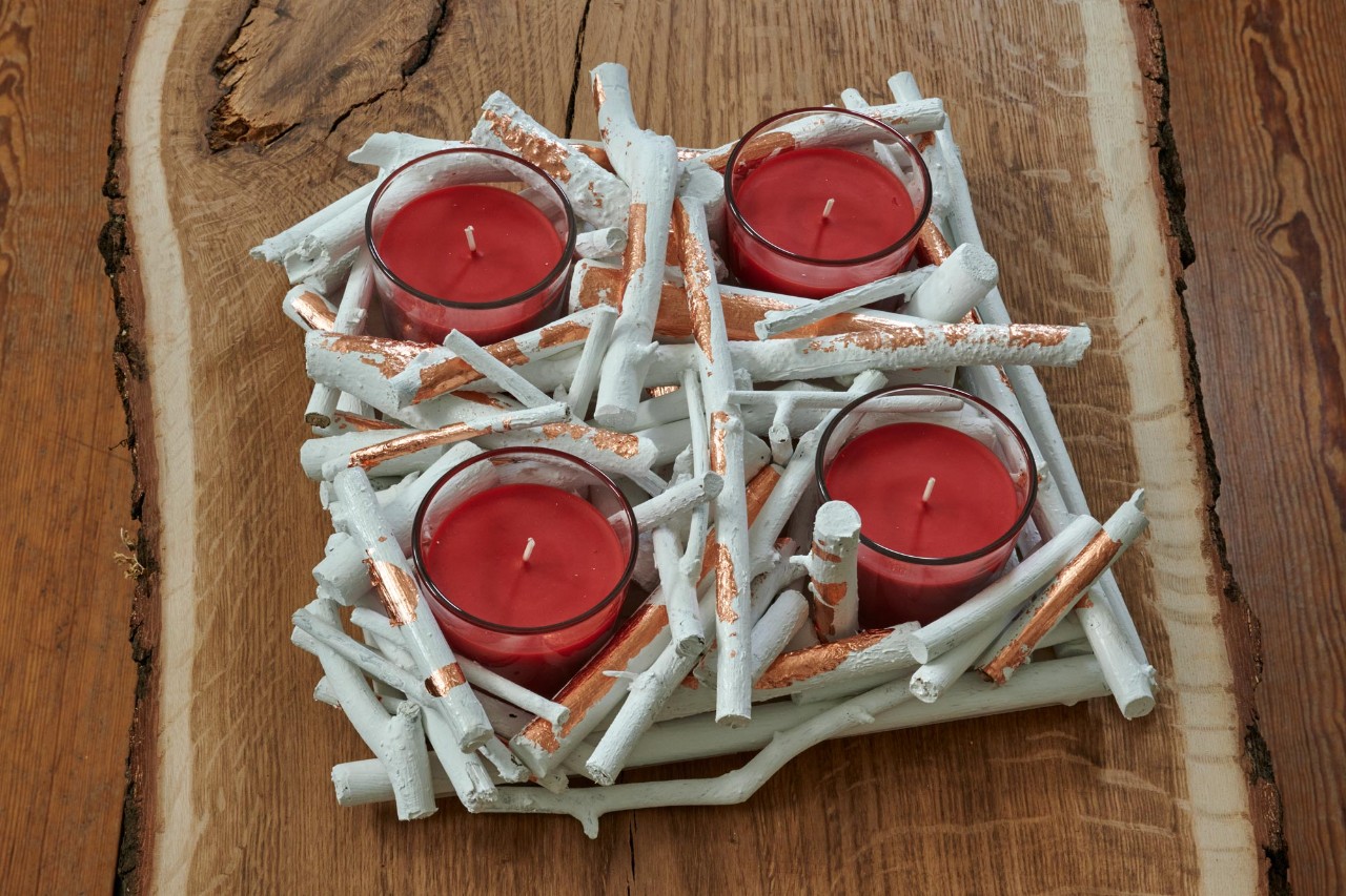 Fertiggestellter Adventskranz aus Ästen zum Selbermachen mit vier roten Teelichtern 