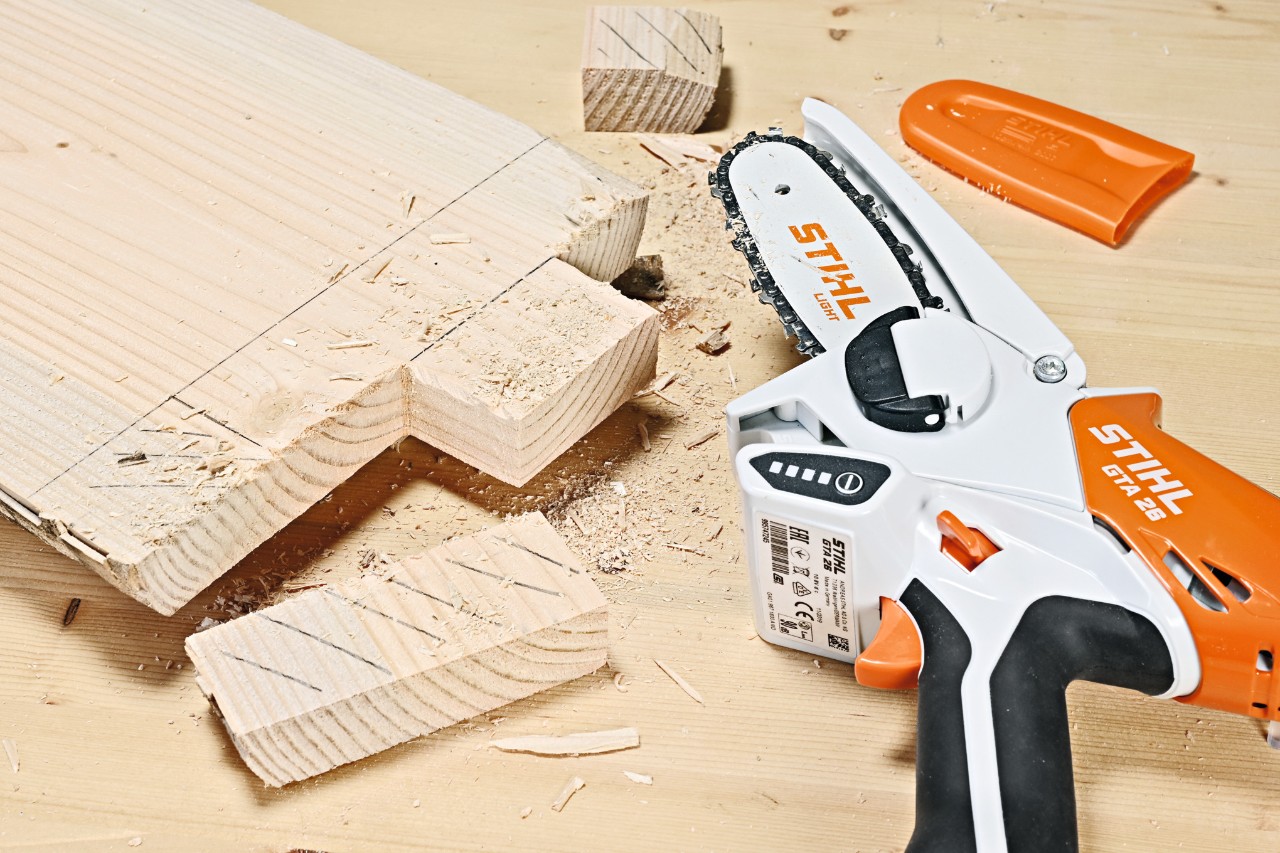 Aus einer Holzbohle werden mit dem STIHL Akku-Gehölzschneider GTA 26 Aussparungen herausgeschnitten
