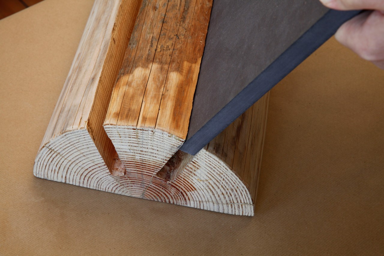 Platten der Hockerbeine werden in Aussparung an Holzstamm geschoben, um Baumstamm-Hocker selber zu machen