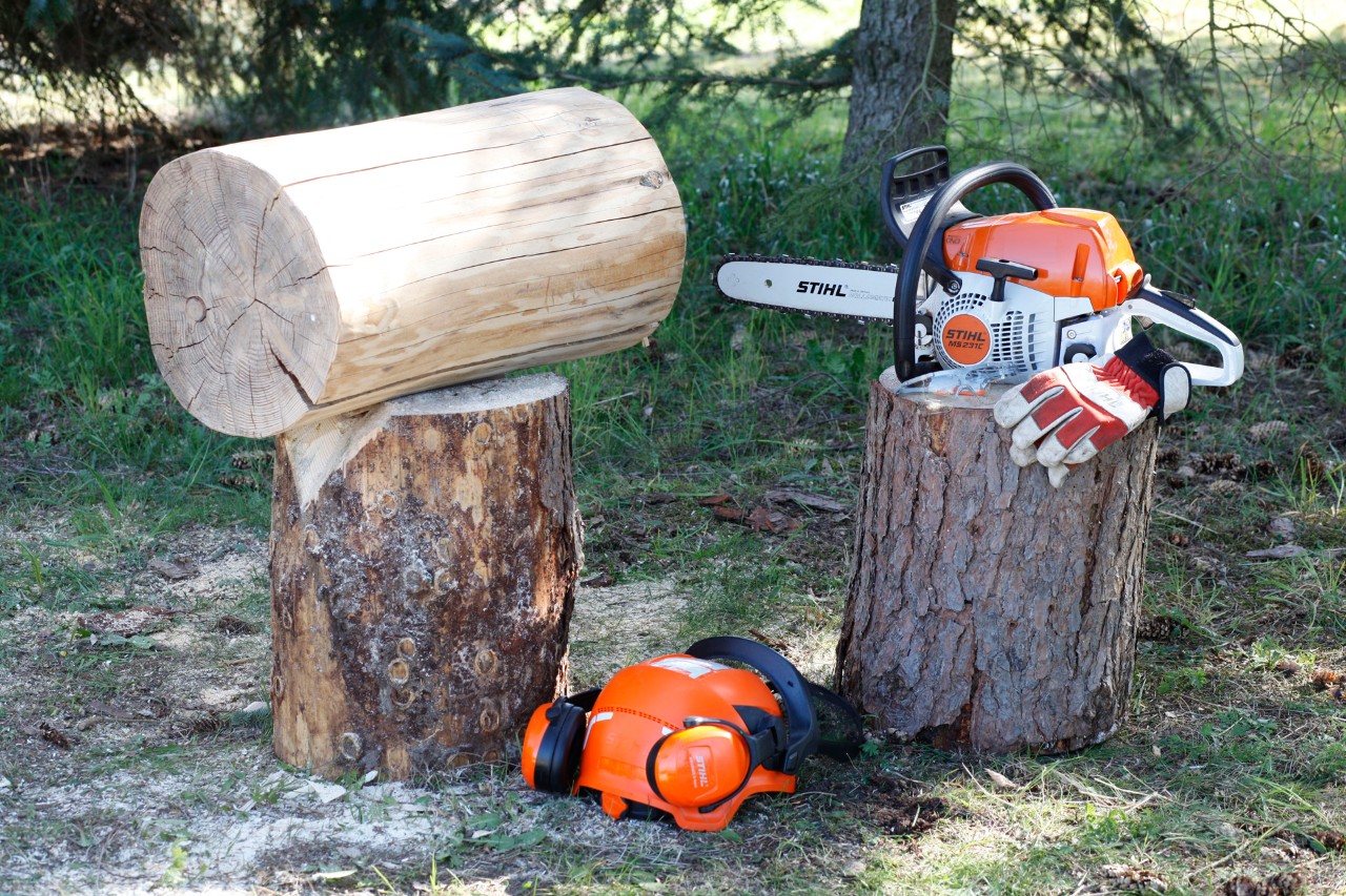  Baumstamm, STIHL Benzin-Motorsäge MS 231 C, Handschuhe, Helm und Gehörschutz liegen bereit, um Hocker selber zu machen