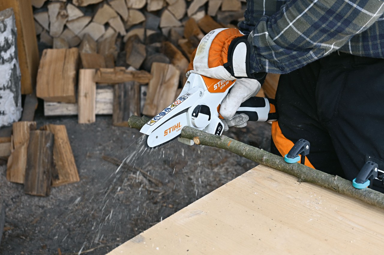 Nahaufnahme, wie eine Person mit dem Akku-Gehölzschneider STIHL GTA 26 einen Ast zerteilt