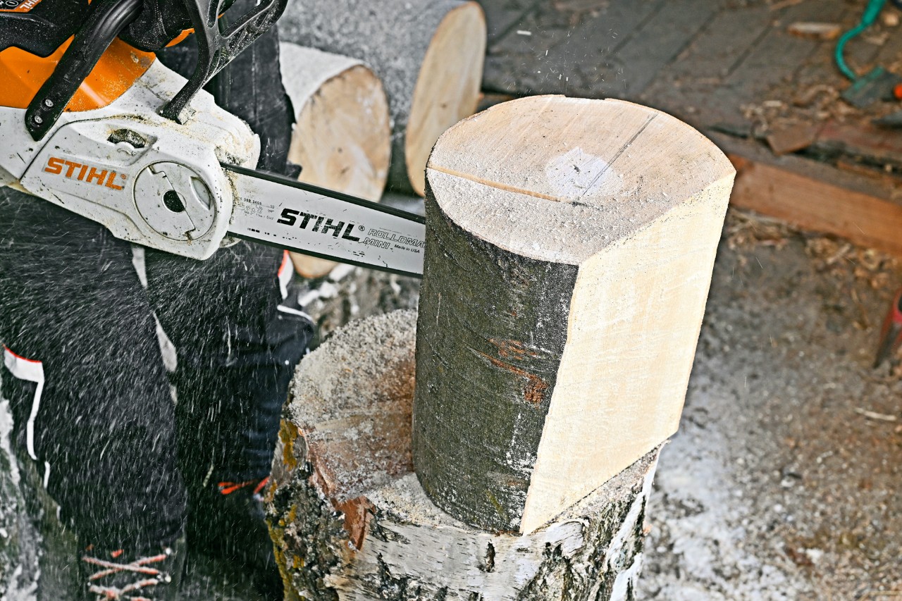 Für einen Zeitungsständer zum Selberbauen wird mit einer STIHL Akku-Kettensäge MSA 140 C eine Aussparung aus Holzstück gesägt