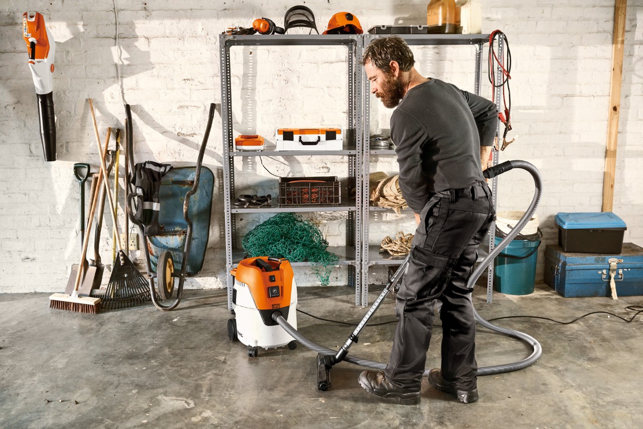 Mann saugt den den Boden einer Garage mit dem STIHL Nass- und Trockensauger SE 62 E