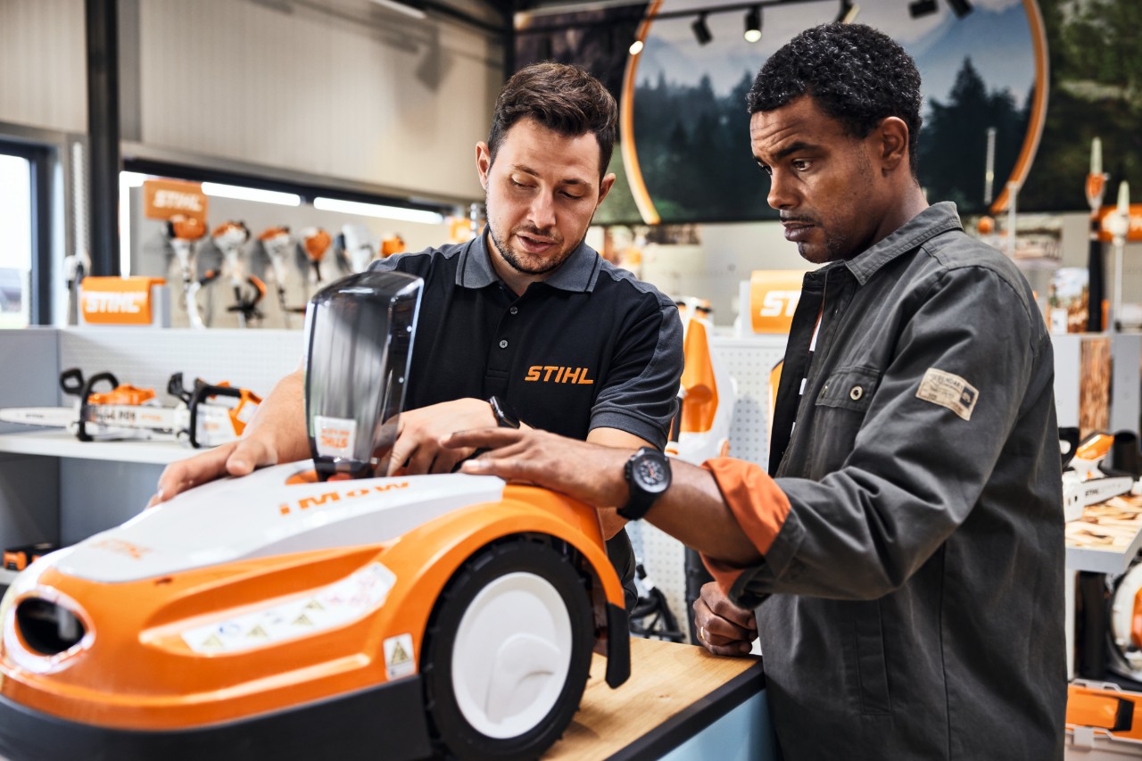 STIHL Fachhändler berät Mann beim Kauf eines STIHL iMOW Mähroboters