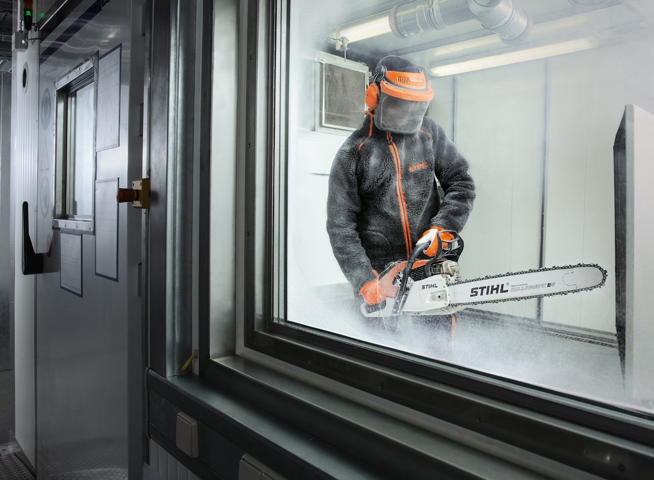 Person in Schutzkleidung testet STIHL Kettensäge in einer Klimakammer